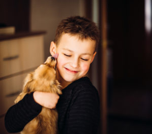 Pretty child hugs little dog